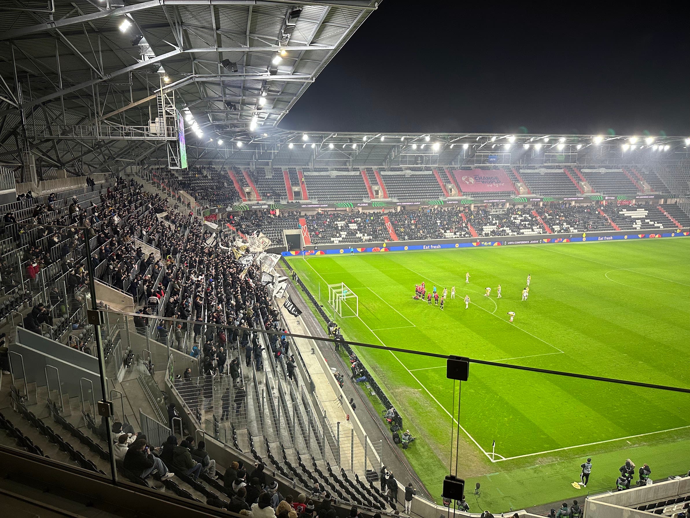 The LASK ultras section in full voice with flags and banners during the match against Víkingur Reykjavík.